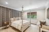 Recessed lighting, crown molding, patterned accent wall, wood-finish flooring, and a large window with privacy shades