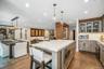 Open-concept kitchen and dining area featuring wood-finish flooring, recessed lighting, and a kitchen island with built-in appliances