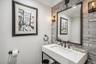 Floating vanity with integrated basin, dark bronze faucet and fixtures, paired with a large rectangular mirror
