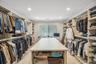 Custom closet system featuring extensive shelving, hanging rods, and pull-out drawers