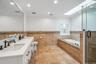 Dual vanity with white cabinetry and dark hardware, set against a full-width mirror