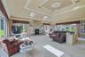 Vaulted ceiling with decorative medallion and ceiling fan, skylights, stone-clad fireplace, and expansive windows