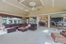 Vaulted ceiling with recessed lighting, large windows, tray ceiling with medallion, ceiling fan, and built-in cabinetry
