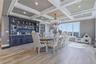 Coffer ceiling with recessed lighting, dark built-in display cabinetry with quartzite counter tops, and large picture windows