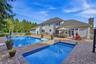 Expansive paver patio with a rectangular pool and an additional plunge pool