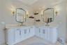 Dual vanity with white cabinetry and black hardware, marble flooring