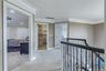 Upper-level hallway with carpeted flooring, crown molding, recessed lighting, and a wrought iron banister