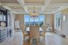 Coffered ceiling with recessed lighting, built-in cabinetry, large windows, mountain views and a chandelier