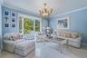 Formal living room, bay window offering natural light, polished tile flooring, and crown molding