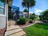 THIS IS THE RIGHT SIDE OF THE HOME WITH TRAVERTINE STEPS LEADING TO THE POOL AREA.