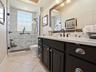 LOVELY RENOVATED GUEST BATH WITH FRAMELESS GLASS DOOR TO THE TILED SHOWER, QUARTZ COUNTERS FRAMED MIRROR AND NEW LIGHT FIXTURE.  ALL OF THE TOILETS IN