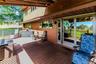Expansive outdoor deck with wood-finish flooring, sliding glass doors, and a wood-paneled exterior