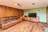 Wood-paneled accent wall, wood-finish flooring, recessed ceiling lighting, and track lighting fixture