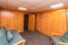 Wood paneling accentuates the walls, complemented by a drop ceiling with integrated lighting