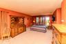 Expansive room with carpeted flooring, multiple windows, and a wall-mounted television bracket