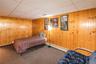 Wood paneling walls complement a drop ceiling with integrated lighting