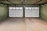 Two-car garage featuring concrete flooring and two white overhead doors with individual window panels