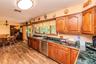 Wood-finish flooring throughout, solid wood cabinetry, dark countertops, stainless steel dishwasher, and sliding glass door