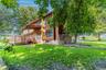 Multi-level exterior with wood siding, expansive wood deck, and abundant windows