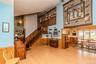 Vaulted ceiling, wood-finish flooring, wood paneling, open-concept design, and a multi-level staircase with wood railing