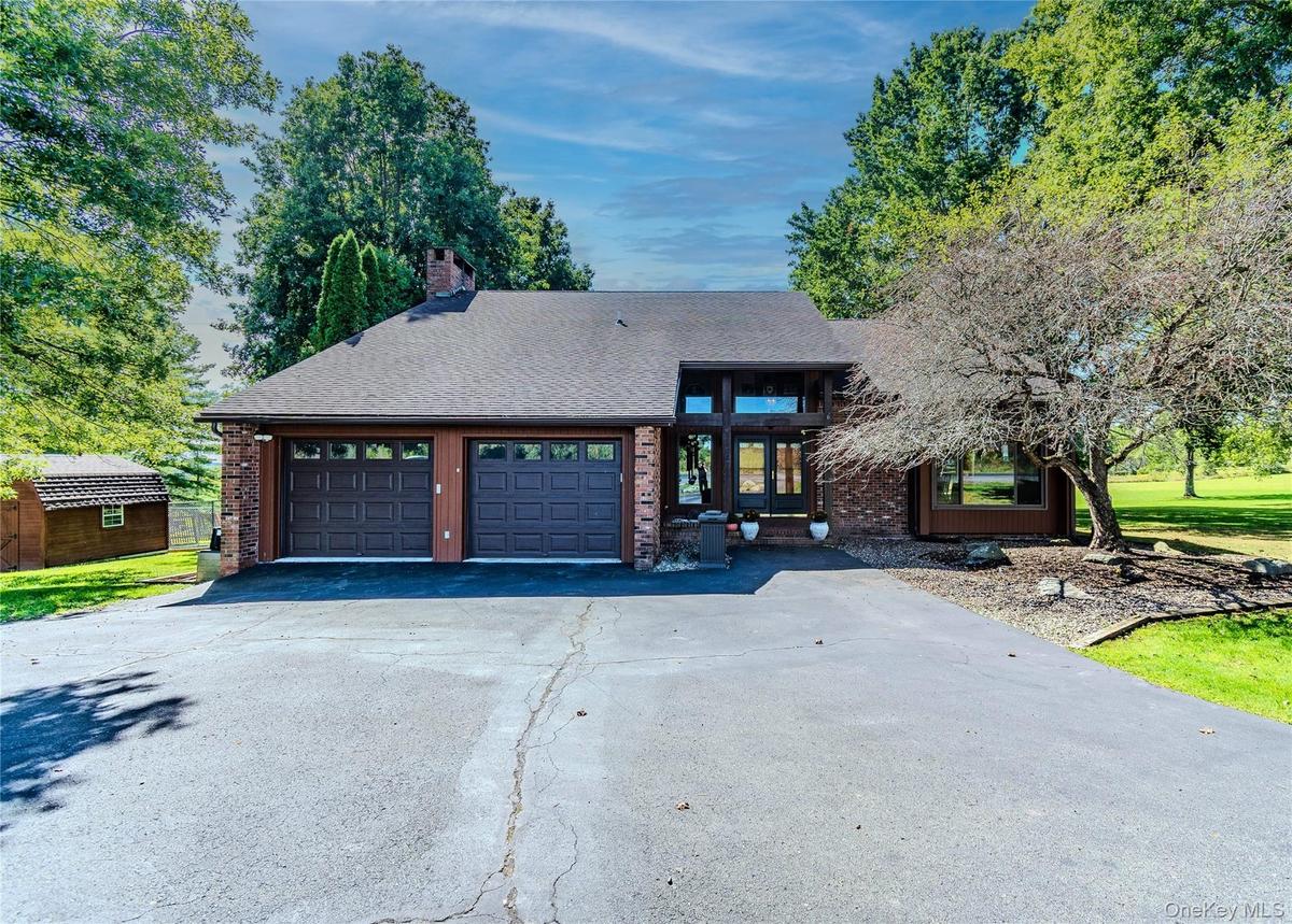 Brick facade with dual attached garage featuring panel doors and window inserts