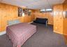 Wood-paneled walls with carpet flooring and a drop ceiling