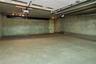 Expansive garage space with concrete flooring, overhead lighting, and two garage door openers