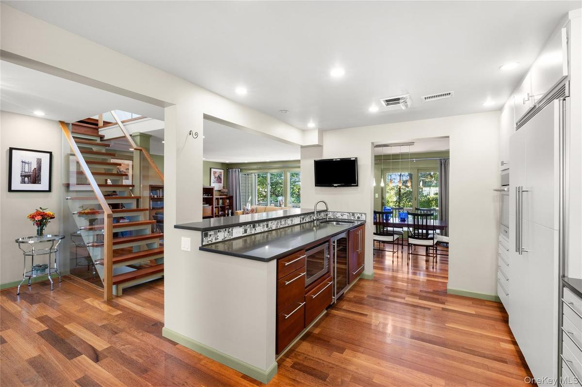 Kitchen peninsula features quartz countertops, wine bar and prep sink