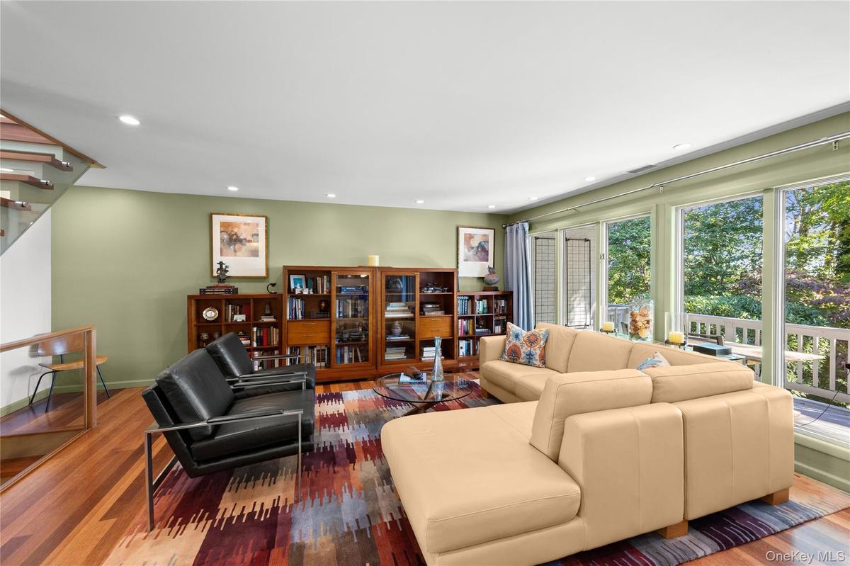 Living room with floor to ceiling windows recessed lighting and Kempas HW floors throughout