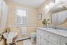 White vanity with a marble countertop, undermount sink, and chrome faucet