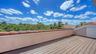 An expansive rooftop terrace creates a remarkable outdoor vantage point above the surrounding treetops.