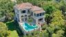 An aerial perspective reveals the home's exceptional privacy, elevated pool terrace and lush natural surroundings.