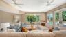 Expansive windows and French doors surround this comfortable gathering space with views of the lush tropical setting.