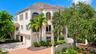 Graceful arched windows, a tile roof and distinctive architectural details give the residence its signature Mizner inspired style.