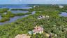 The residence is embraced by mature vegetation and the waterways surrounding Little Sarasota Bay.