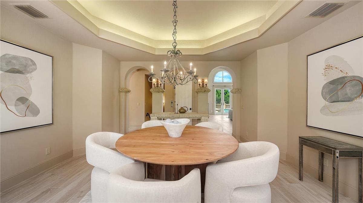 The dining room's graceful proportions and architectural detailing create an inviting space for memorable gatherings.