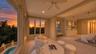 The primary sitting area captures the warm glow of sunset over the surrounding coastal landscape.