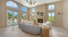 Walls of windows and French doors fill the great room with natural light while connecting the interior to the surrounding landscape.