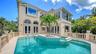French doors open directly to the pool terrace, seamlessly connecting the home with its private outdoor setting.