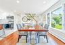 Spacious dining area featuring rich wood-finish flooring, abundant natural light from large windows, recessed lighting, and an open concept layout