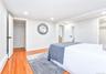 Hardwood flooring extends throughout this room, featuring recessed lighting and white baseboards