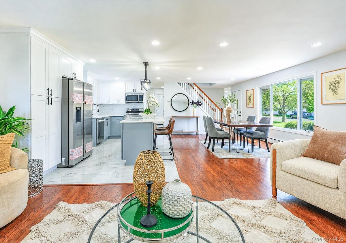 Open-concept living space with wood-finish flooring extending into the dining area