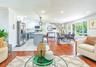 Open-concept living space with wood-finish flooring extending into the dining area