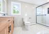 Bathroom featuring a wood-finish vanity with matte black hardware, white rectangular sink, and wall-mounted faucet
