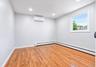 Room featuring hardwood flooring, white baseboards, recessed lighting, and a white-framed window