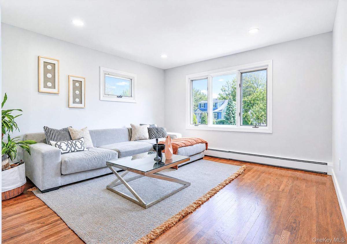 Spacious room featuring wood-finish flooring, white baseboards, and light gray wall paint