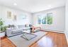 Spacious room featuring wood-finish flooring, white baseboards, and light gray wall paint