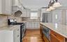 Hardwood flooring, light-toned cabinetry, and stone countertops