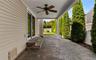 Covered patio featuring a ceiling fan, paver flooring, sliding glass doors, and privacy landscaping