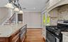 Gourmet kitchen with granite countertops, stainless steel appliances, built-in microwave, and wood-finish flooring